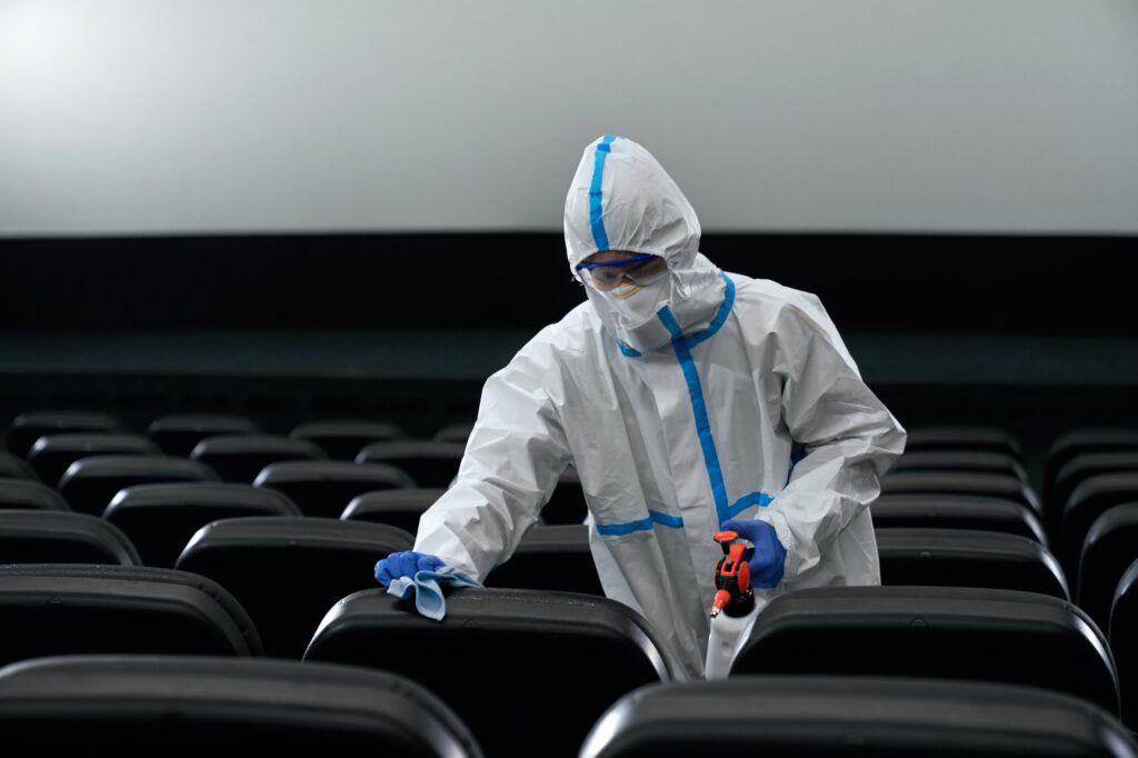 Man in protective suit disinfect cinema hall.